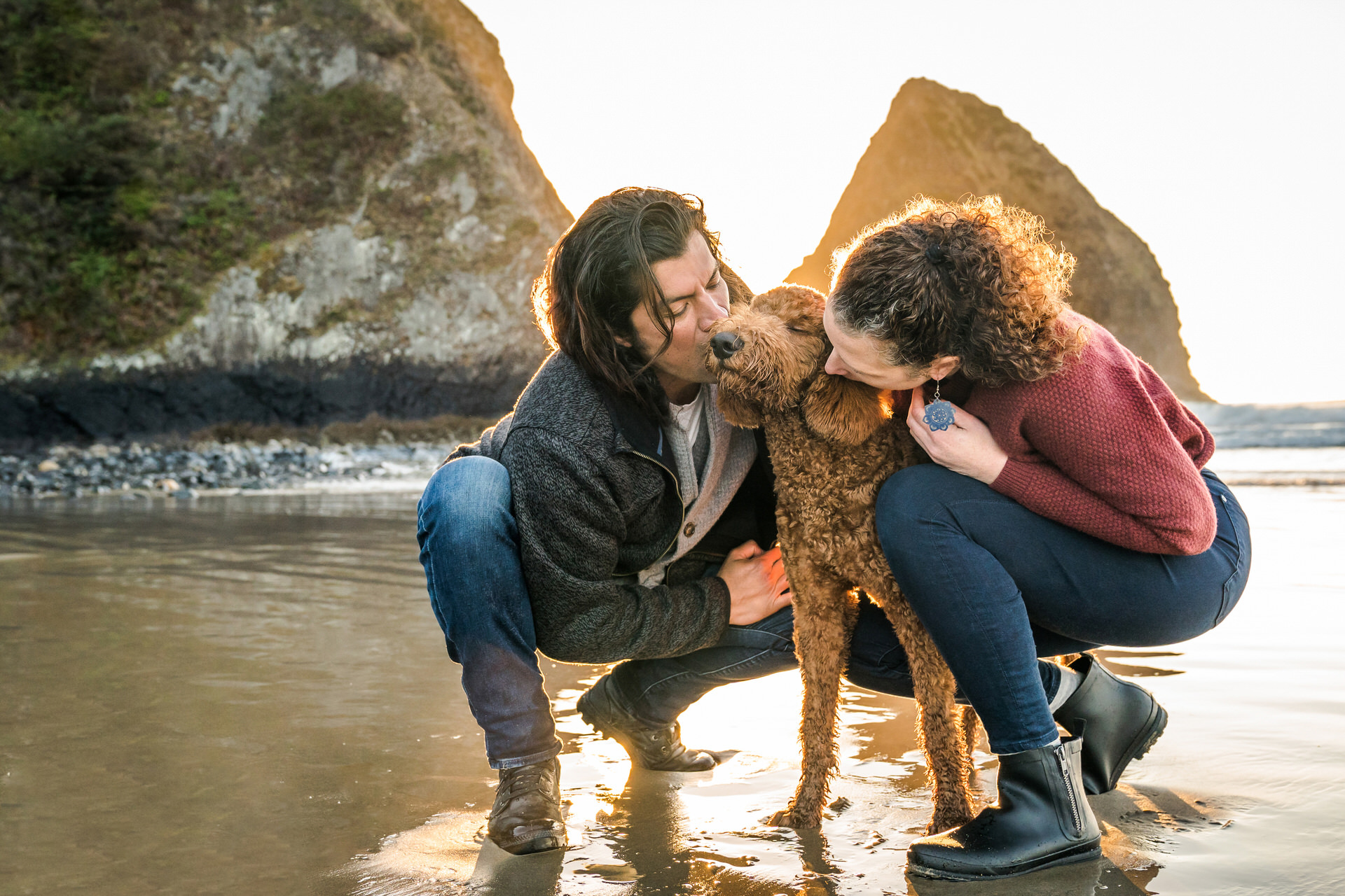 couple kissing dog with all of their eyes closed
