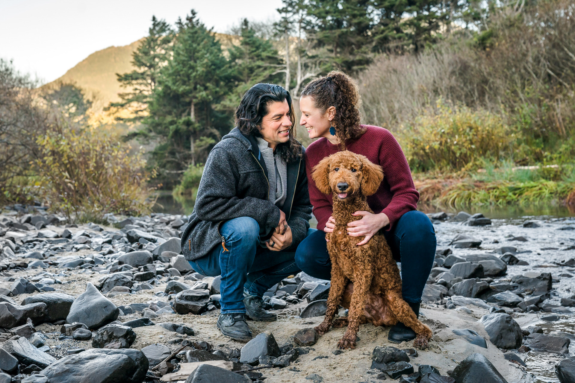 couple with dog on river beach in Oregon