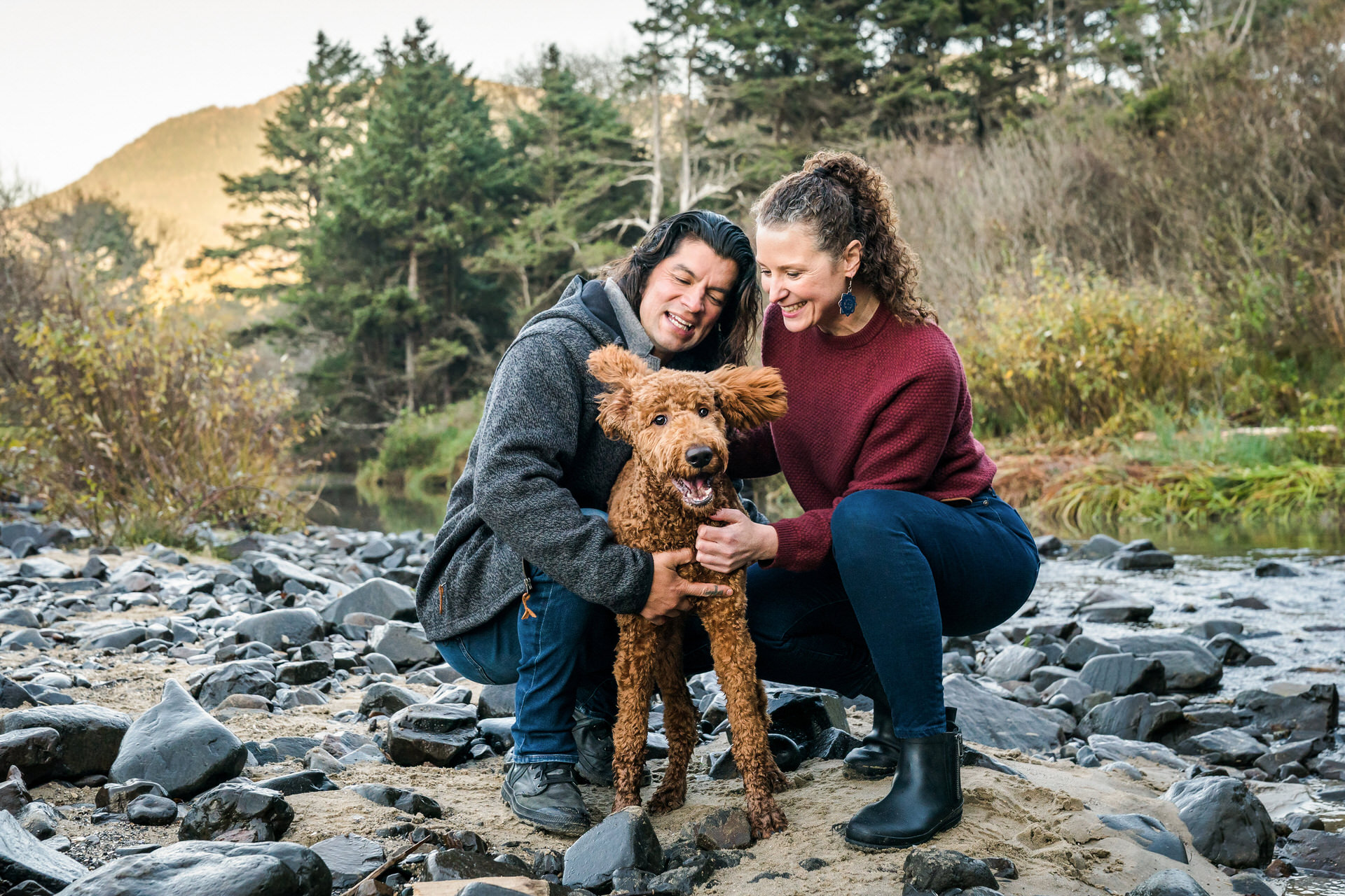funny dog with couple on a river beach