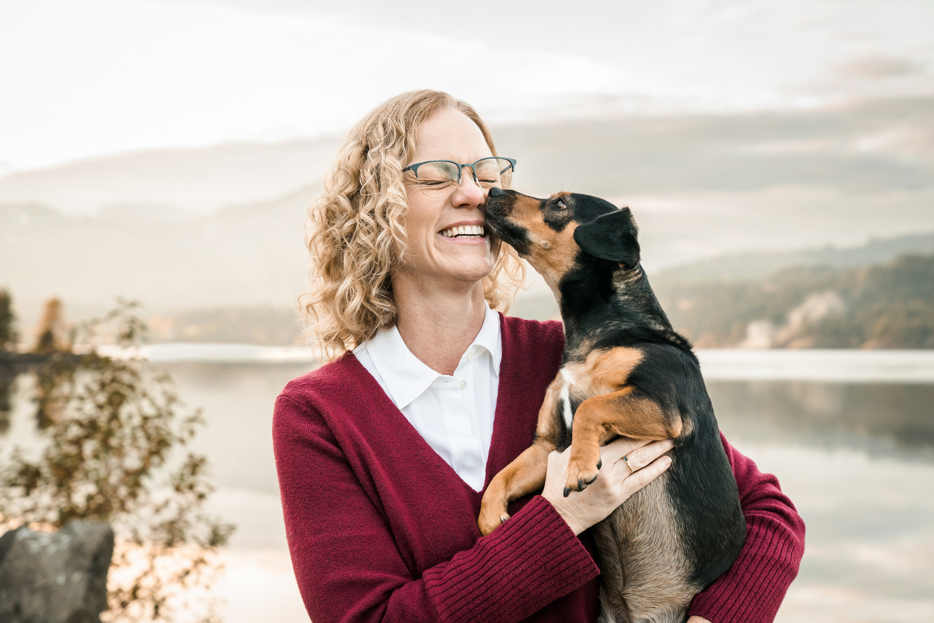 dog kisses woman on cheek