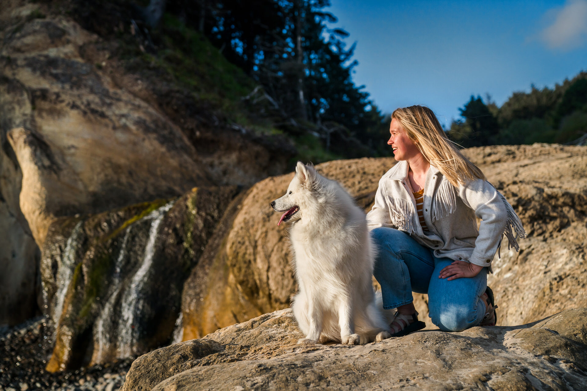 dog and woman look into the ocean at the oregon coast