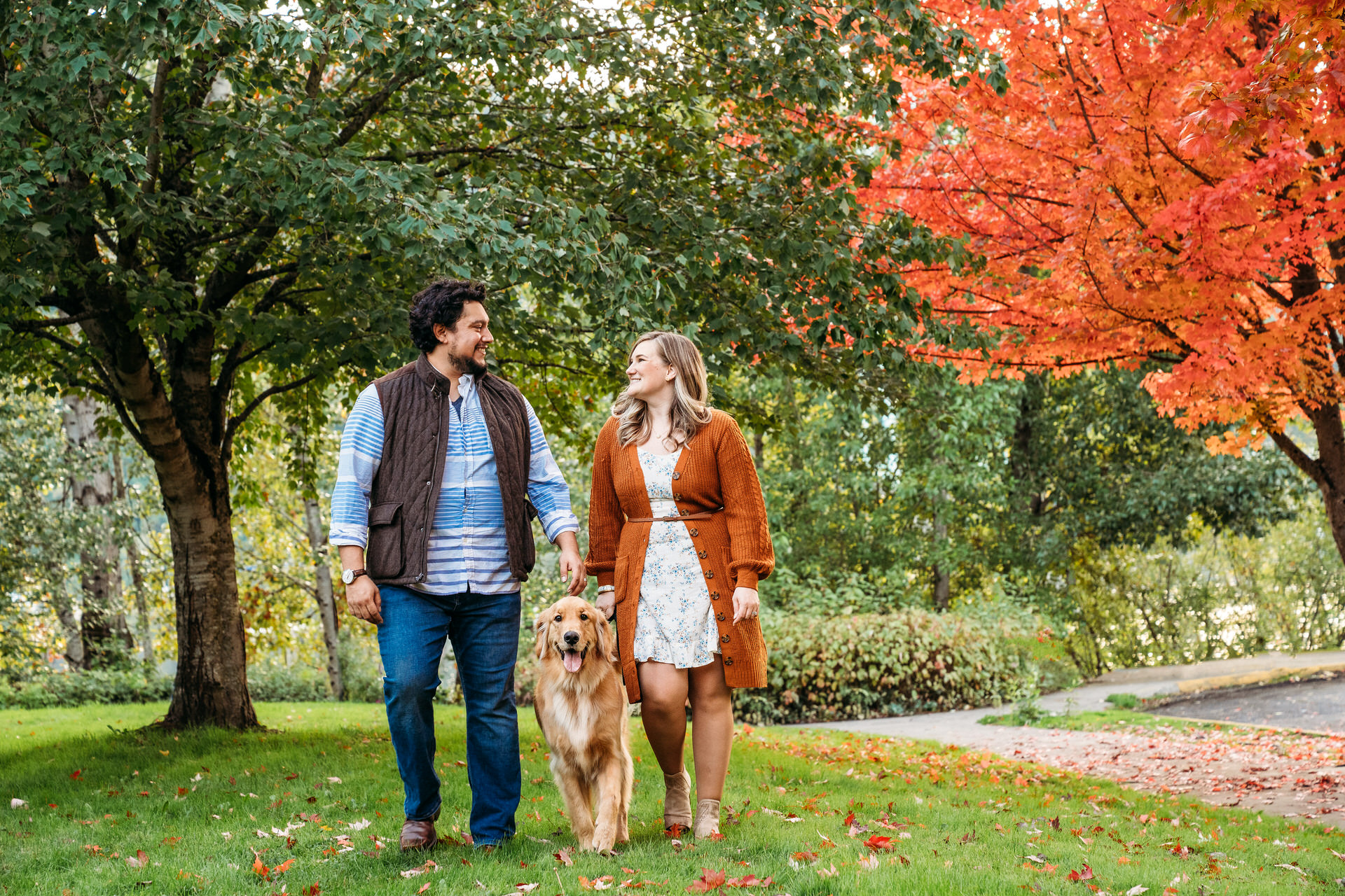 couple walks with dog at the best place for a fall photo session in portland oregon