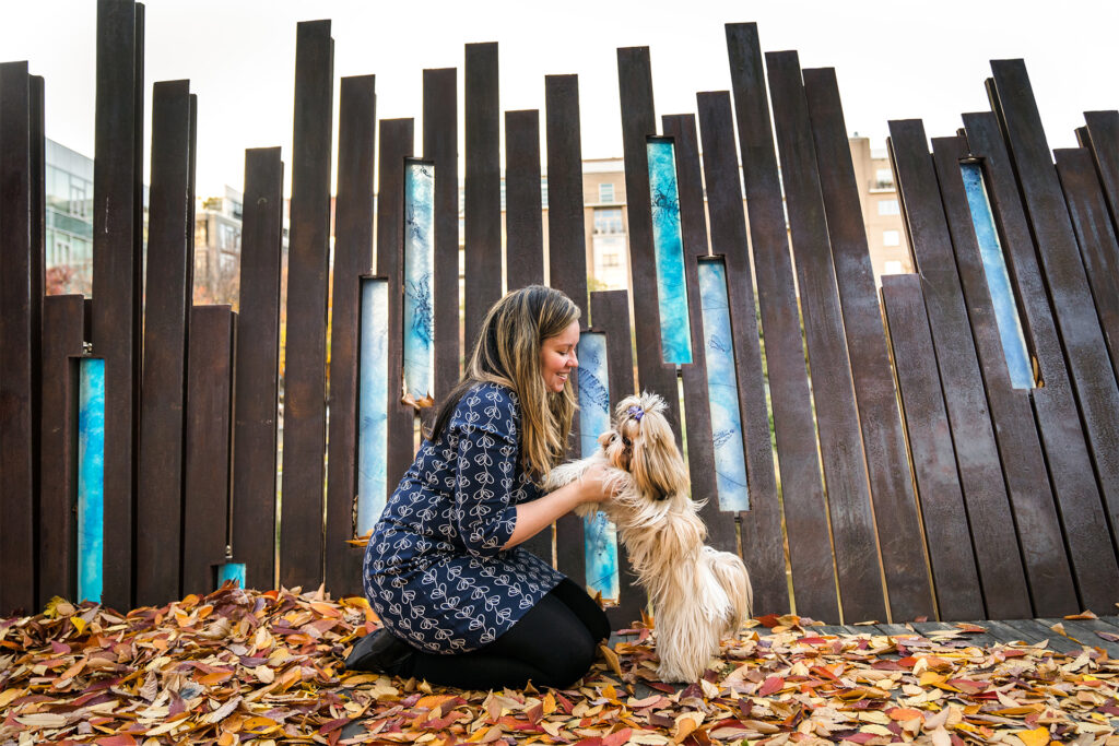 Woman and her shih tzu dog sitting in fallen leaves in the Pearl District