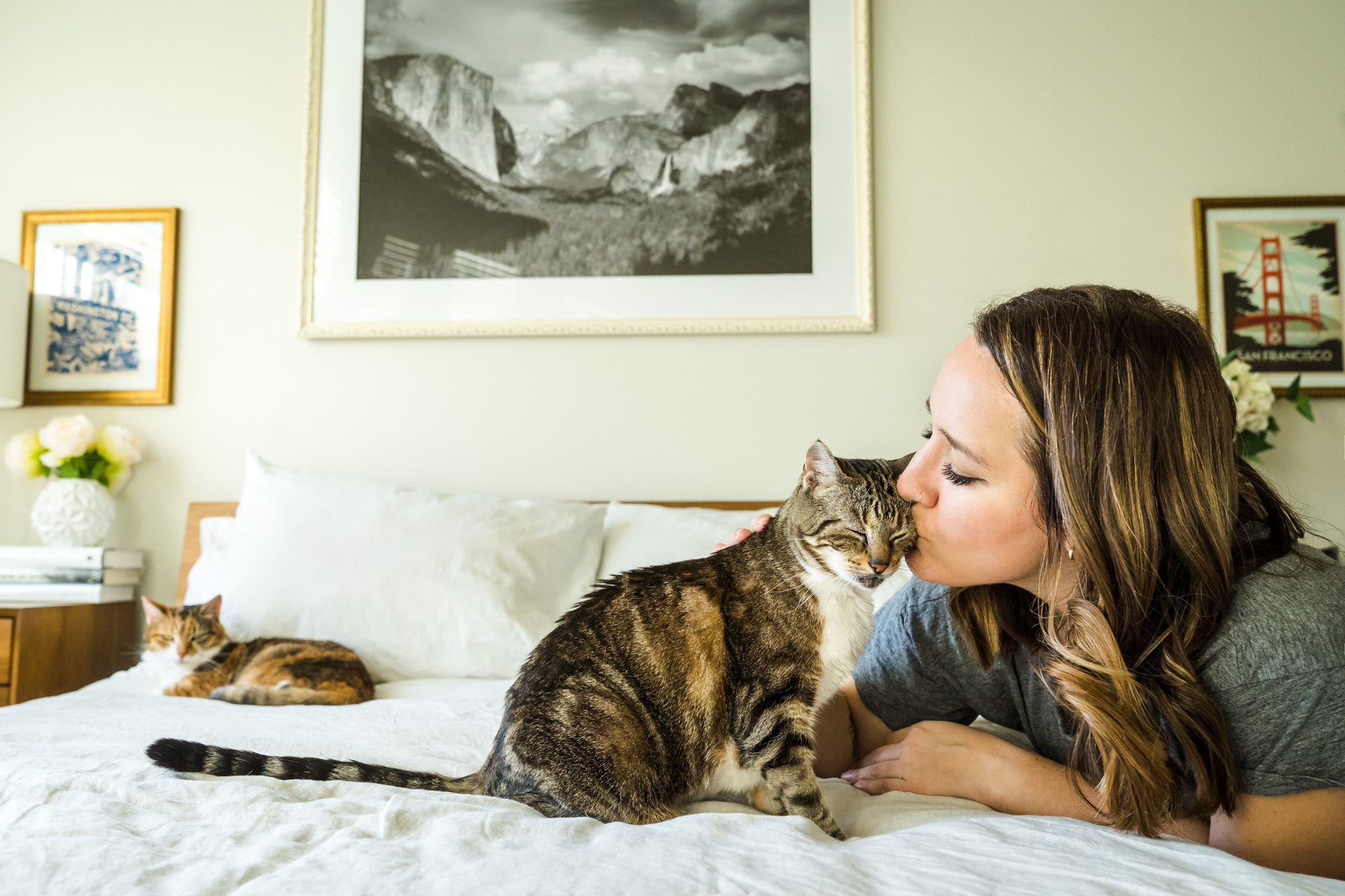 Woman kisses her cat with eyes closed