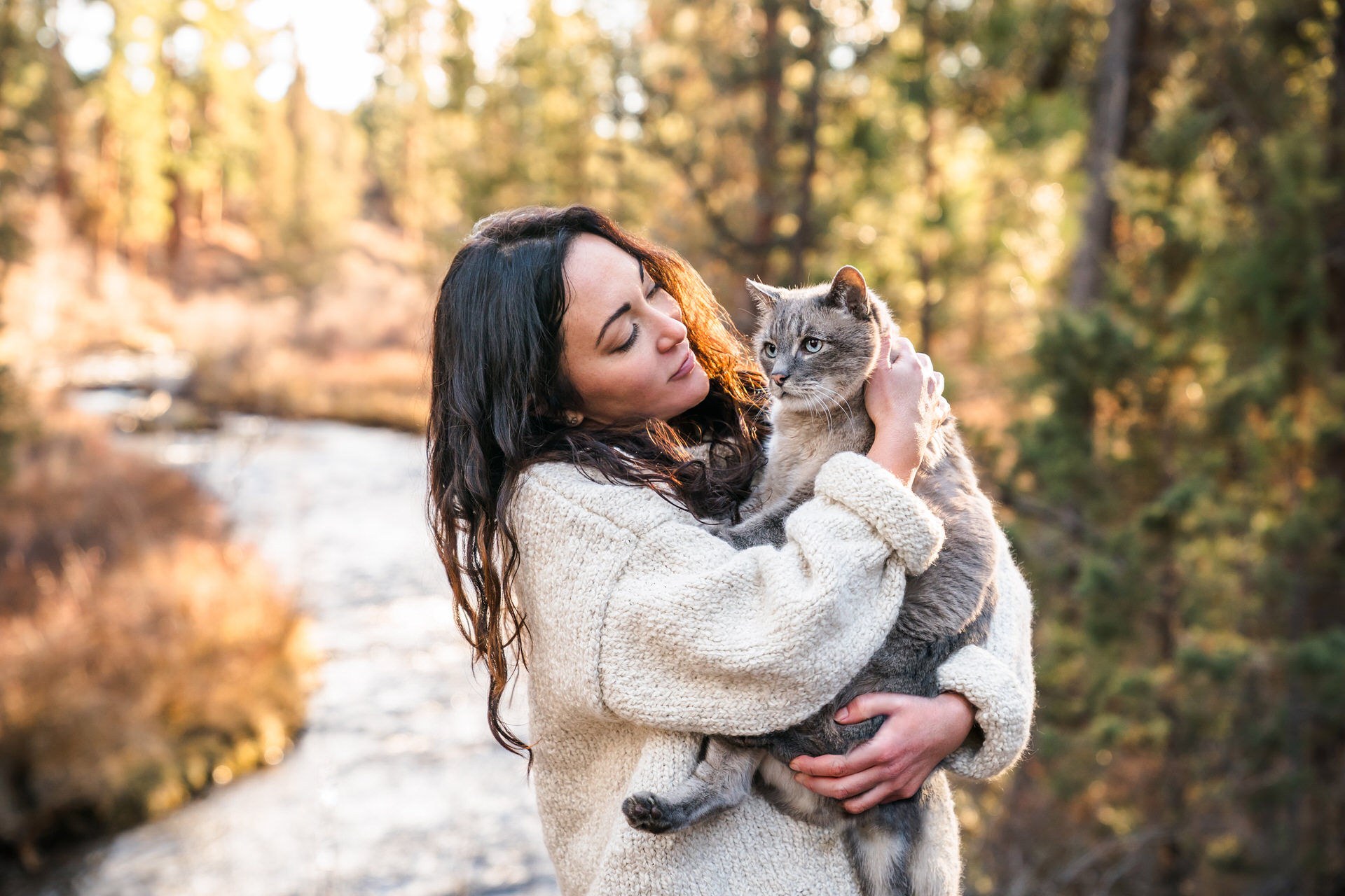 Woman cuddling cat outdoors